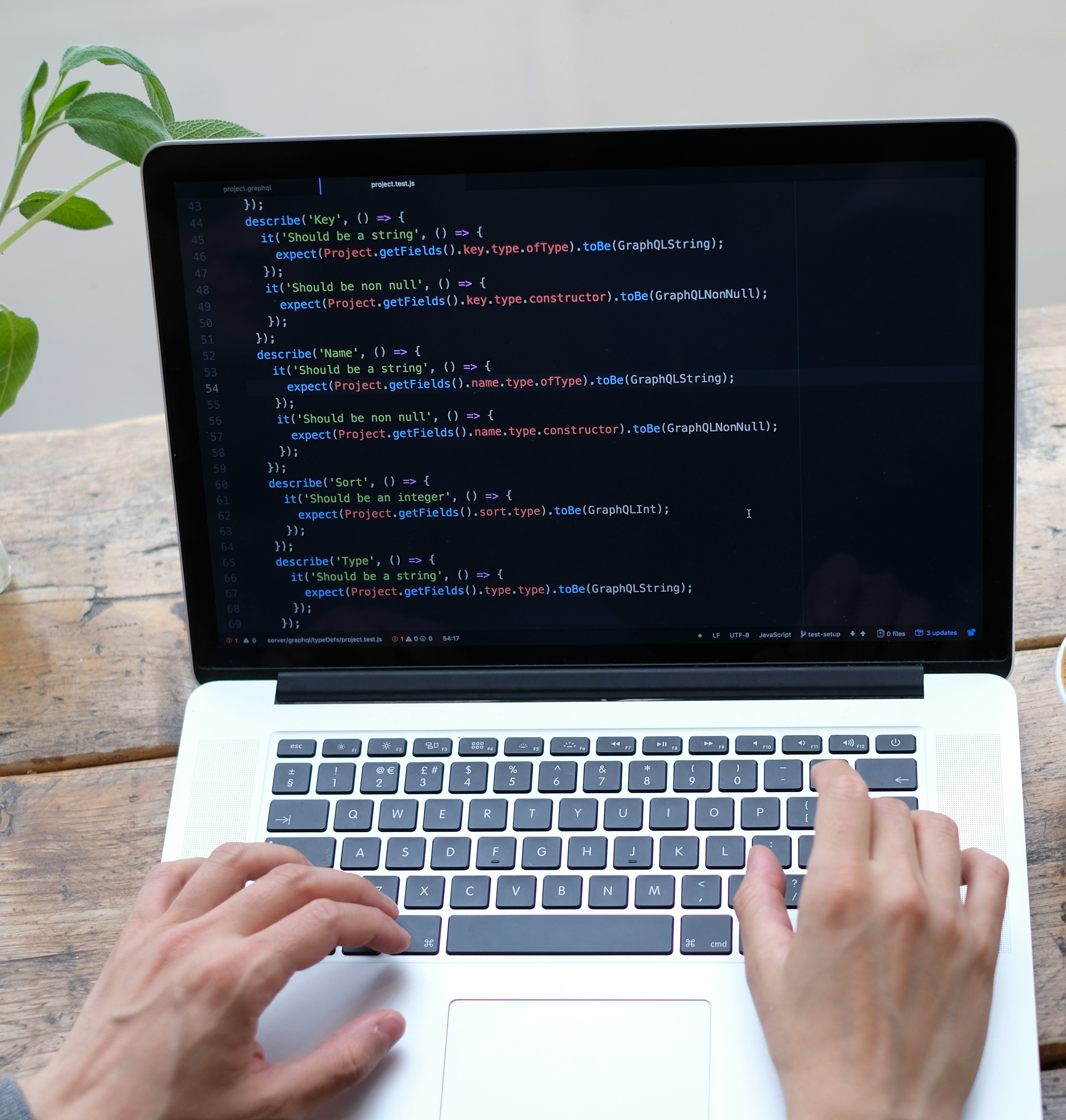 Man's hands coding on a grey laptop